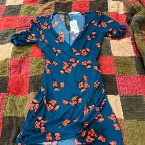 Small blue dress with red flowers. Dress falls to around the knees.